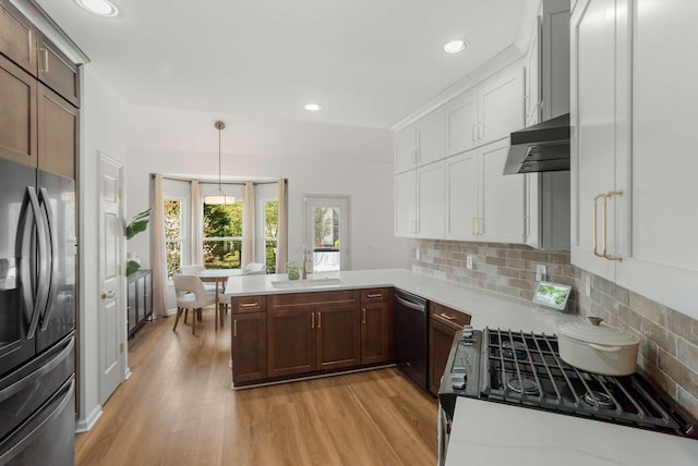 6525 Chessington Dr, Nashville, TN 37221 - kitchen with light countertops, under cabinet range hood, freestanding refrigerator, dishwashing machine, and a peninsula