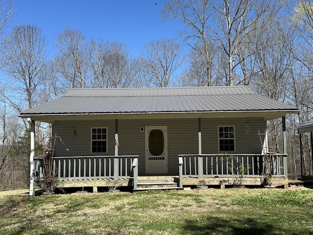 view of front of house with covered porch, metal roof, and a front yard