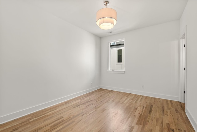 spare room with visible vents, baseboards, and light wood-type flooring