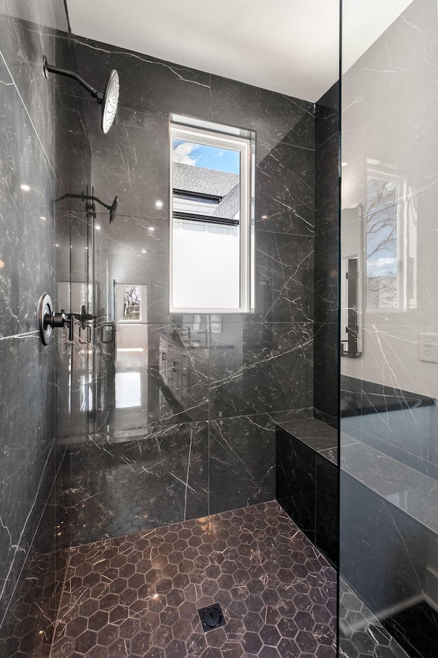bathroom featuring a marble finish shower