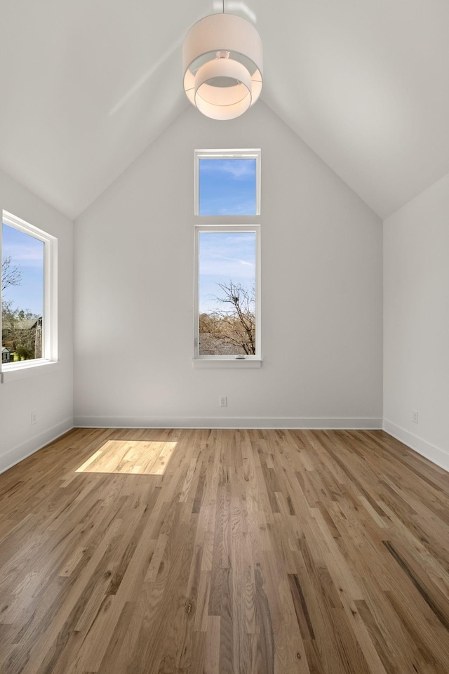 bonus room featuring baseboards, lofted ceiling, and wood finished floors