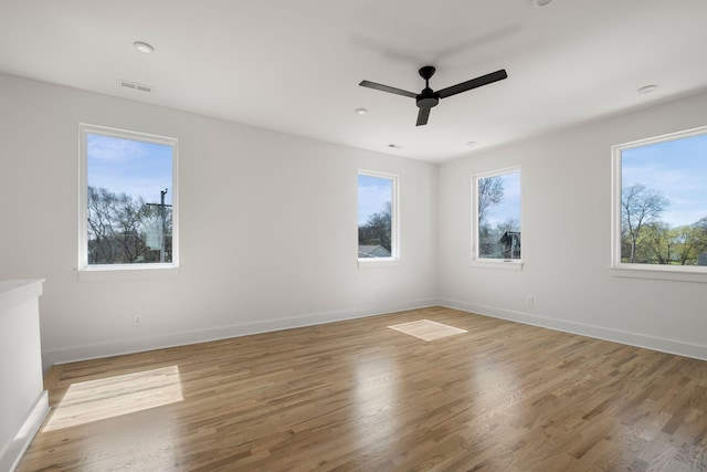 empty room with light wood-style floors and plenty of natural light