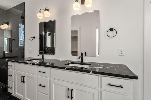 bathroom with double vanity, a sink, and a stall shower