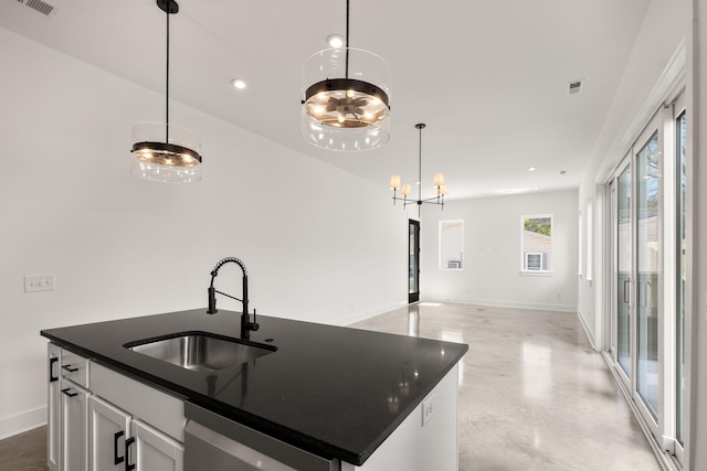 kitchen featuring a sink, a chandelier, baseboards, dark countertops, and concrete flooring