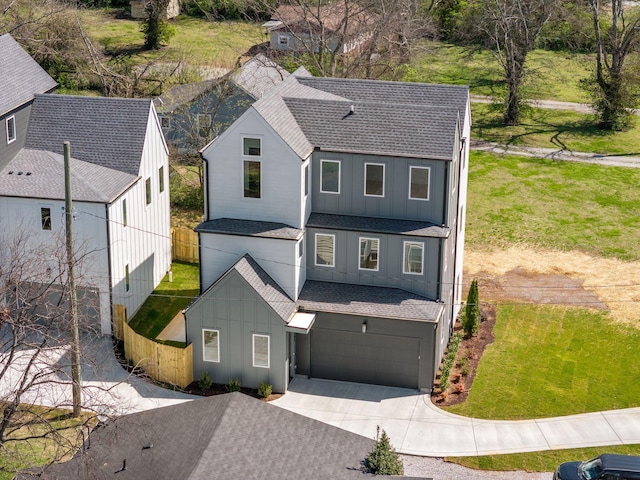 view of front of house with driveway, a shingled roof, an attached garage, and board and batten siding