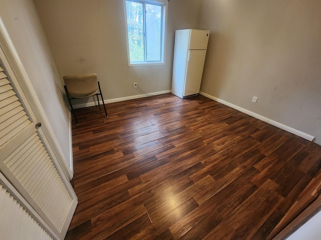 906 Edwards St, Madisonville, KY 42431 - unfurnished bedroom with freestanding refrigerator, baseboards, and dark wood finished floors