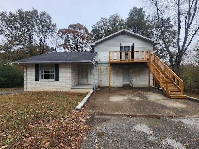 906 Edwards St, Madisonville, KY 42431 - view of front facade with a shingled roof, a wooden deck, brick siding, and aphalt driveway