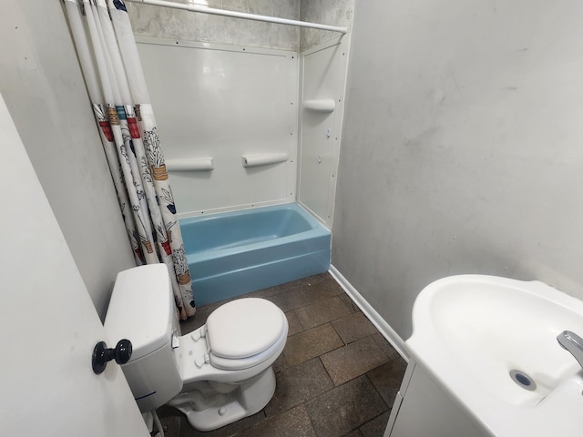 906 Edwards St, Madisonville, KY 42431 - bathroom featuring baseboards, shower / tub combo, toilet, and stone tile flooring