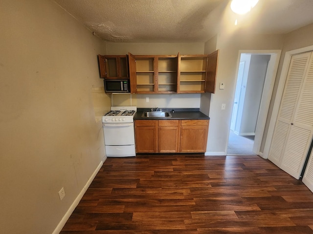 906 Edwards St, Madisonville, KY 42431 - kitchen with a sink, open shelves, white range with gas cooktop, dark countertops, and dark wood-style flooring