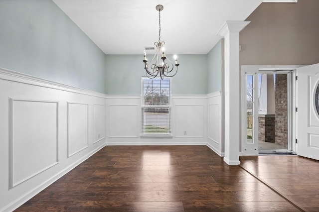 2033 Hidden Cove Rd, Mount Juliet, TN 37122 - unfurnished dining area featuring a decorative wall, visible vents, a chandelier, ornate columns, and dark wood finished floors