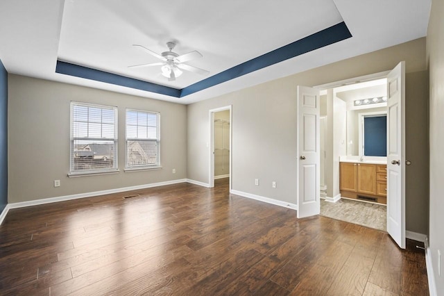 2033 Hidden Cove Rd, Mount Juliet, TN 37122 - unfurnished bedroom featuring dark wood-style floors, a spacious closet, baseboards, and a raised ceiling