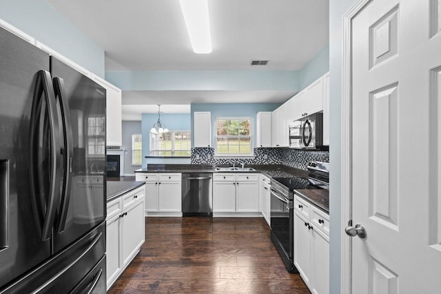 2033 Hidden Cove Rd, Mount Juliet, TN 37122 - kitchen featuring dark countertops, tasteful backsplash, a sink, dark wood-style floors, and black appliances
