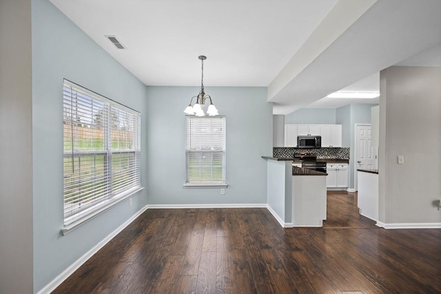 2033 Hidden Cove Rd, Mount Juliet, TN 37122 - kitchen with backsplash, stainless steel appliances, dark countertops, white cabinets, and an inviting chandelier
