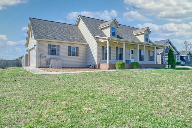 rear view of property featuring an attached garage, covered porch, roof with shingles, and a yard