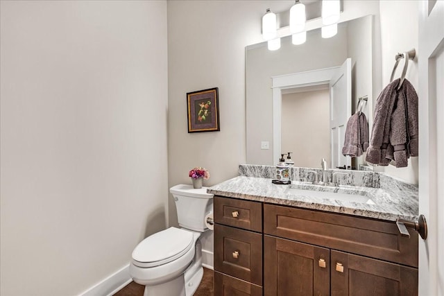 bathroom with vanity, toilet, and baseboards