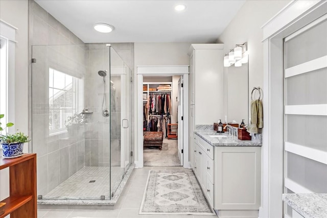 bathroom featuring a shower stall, recessed lighting, tile patterned floors, vanity, and a walk in closet