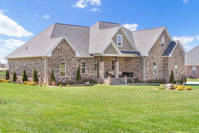 craftsman inspired home featuring brick siding, a shingled roof, and a front yard