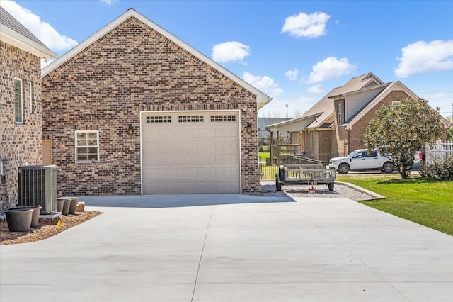 view of home's exterior with driveway, central AC, an attached garage, and brick siding