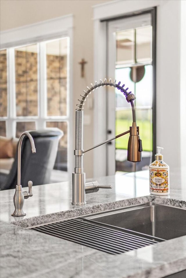 details featuring light stone counters and a sink
