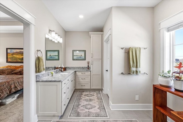 ensuite bathroom with recessed lighting, vanity, connected bathroom, tile patterned floors, and baseboards