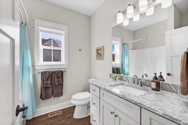 full bath with toilet, visible vents, wood finished floors, and a healthy amount of sunlight