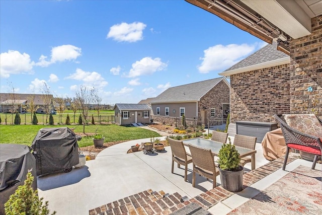 view of patio with an outdoor structure, outdoor dining area, and a fenced backyard