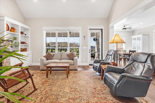 living room featuring a ceiling fan, wood finished floors, lofted ceiling, and a healthy amount of sunlight