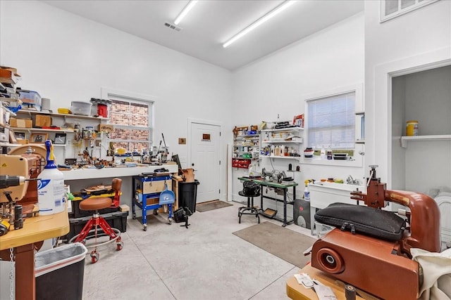 interior space with a workshop area, visible vents, and concrete floors