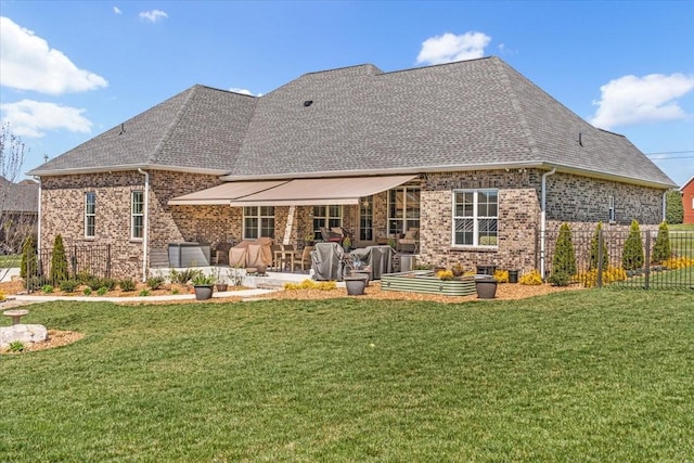 rear view of house featuring a patio, brick siding, fence, and a yard