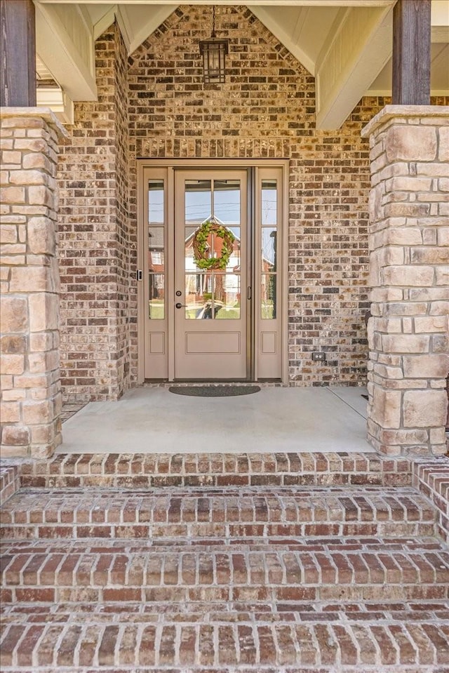 view of exterior entry with brick siding