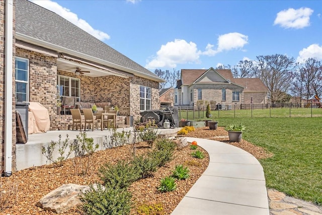view of yard with fence, a ceiling fan, and a patio area