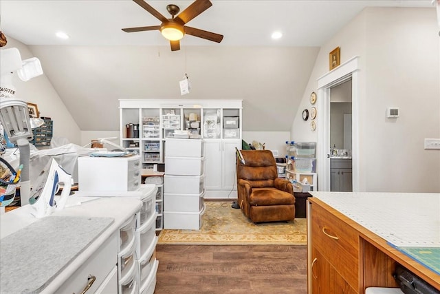 interior space with lofted ceiling, brown cabinets, light countertops, dark wood-type flooring, and a ceiling fan