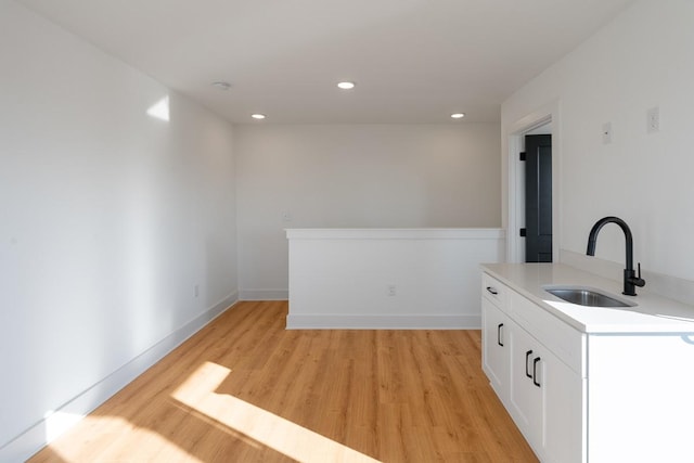 bar with recessed lighting, baseboards, a sink, and light wood-style floors