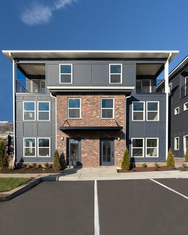view of front of house featuring uncovered parking and brick siding