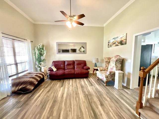 living room with crown molding, a ceiling fan, baseboards, wood finished floors, and stairway