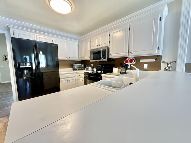 kitchen featuring light countertops, white cabinetry, a sink, and black appliances