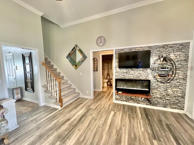 unfurnished living room featuring stairs, baseboards, and wood finished floors
