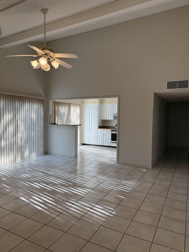 unfurnished living room featuring high vaulted ceiling, ceiling fan, light tile patterned floors, visible vents, and beam ceiling