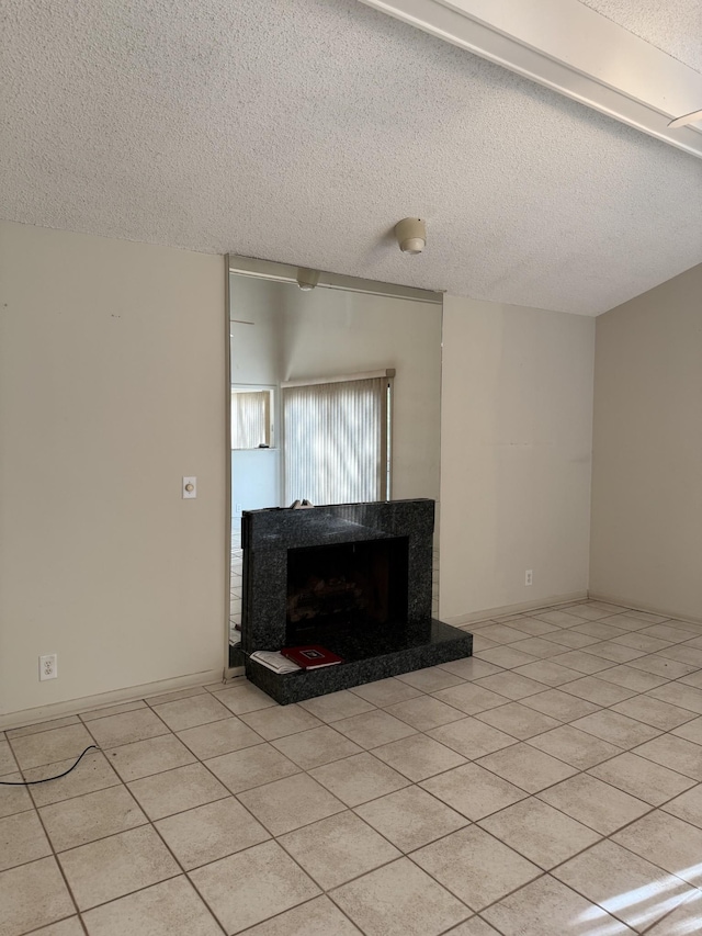 unfurnished living room with light tile patterned flooring, a high end fireplace, and a textured ceiling