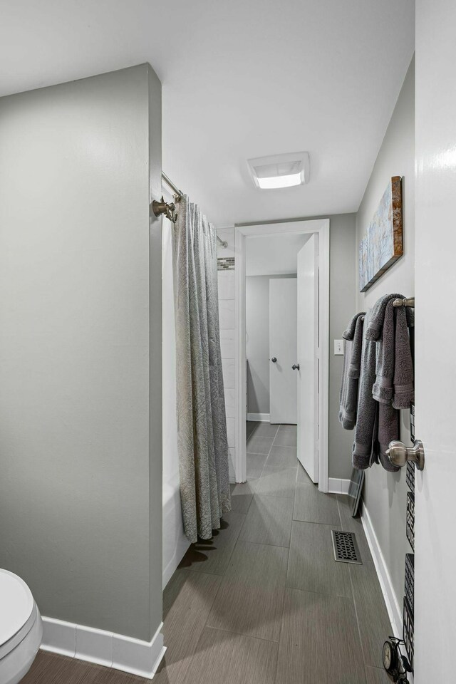 5025 Hillsboro Pike Unit 20E, Nashville, TN 37215 - bathroom with shower / bath combination with curtain, toilet, baseboards, and visible vents