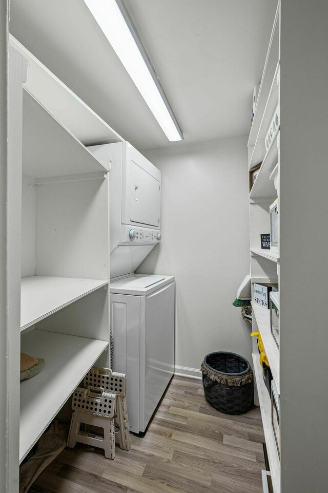 5025 Hillsboro Pike Unit 20E, Nashville, TN 37215 - clothes washing area with baseboards, light wood-style flooring, stacked washer / dryer, and laundry area