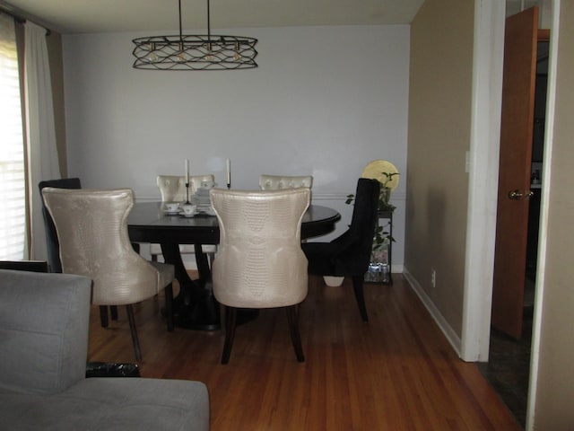 dining area with baseboards and wood finished floors