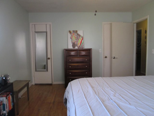 bedroom with baseboards and wood finished floors