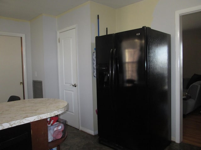 kitchen featuring black fridge, light countertops, baseboards, and visible vents