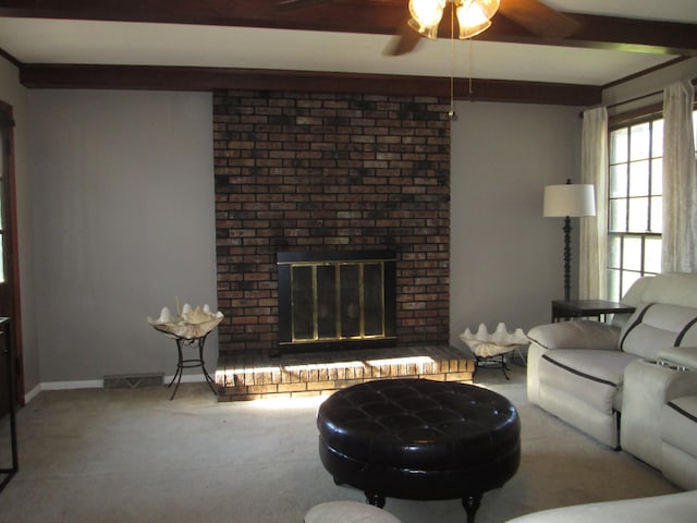 carpeted living room featuring beam ceiling, a ceiling fan, a fireplace, baseboards, and visible vents