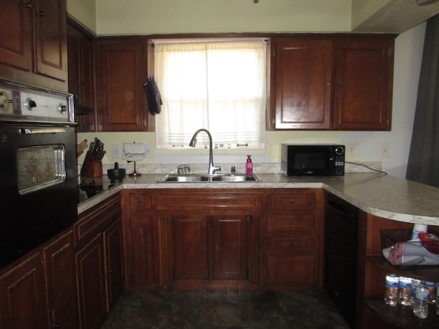 kitchen featuring a sink, light countertops, black appliances, and a peninsula
