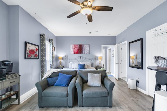 bedroom with baseboards, ceiling fan, and wood finished floors