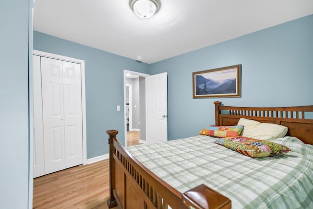 bedroom with baseboards, a closet, and light wood-type flooring