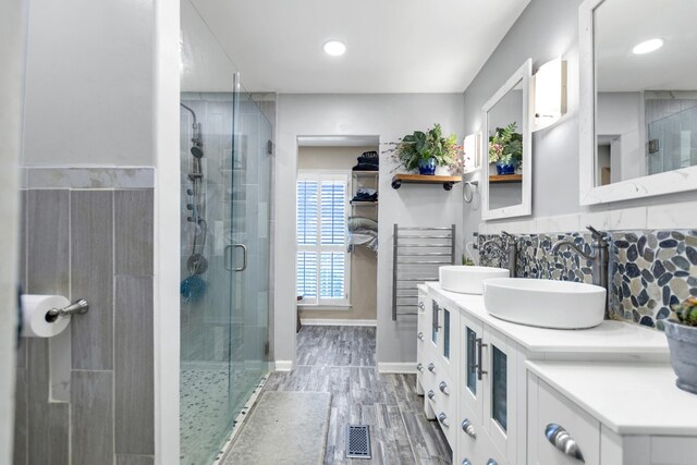 full bath with a shower stall, tasteful backsplash, and a sink