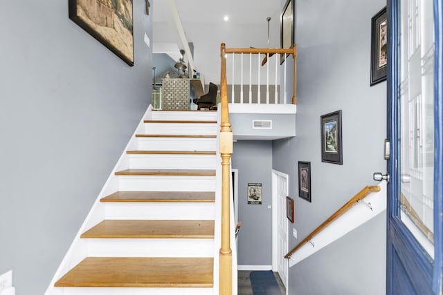 stairs with baseboards and visible vents